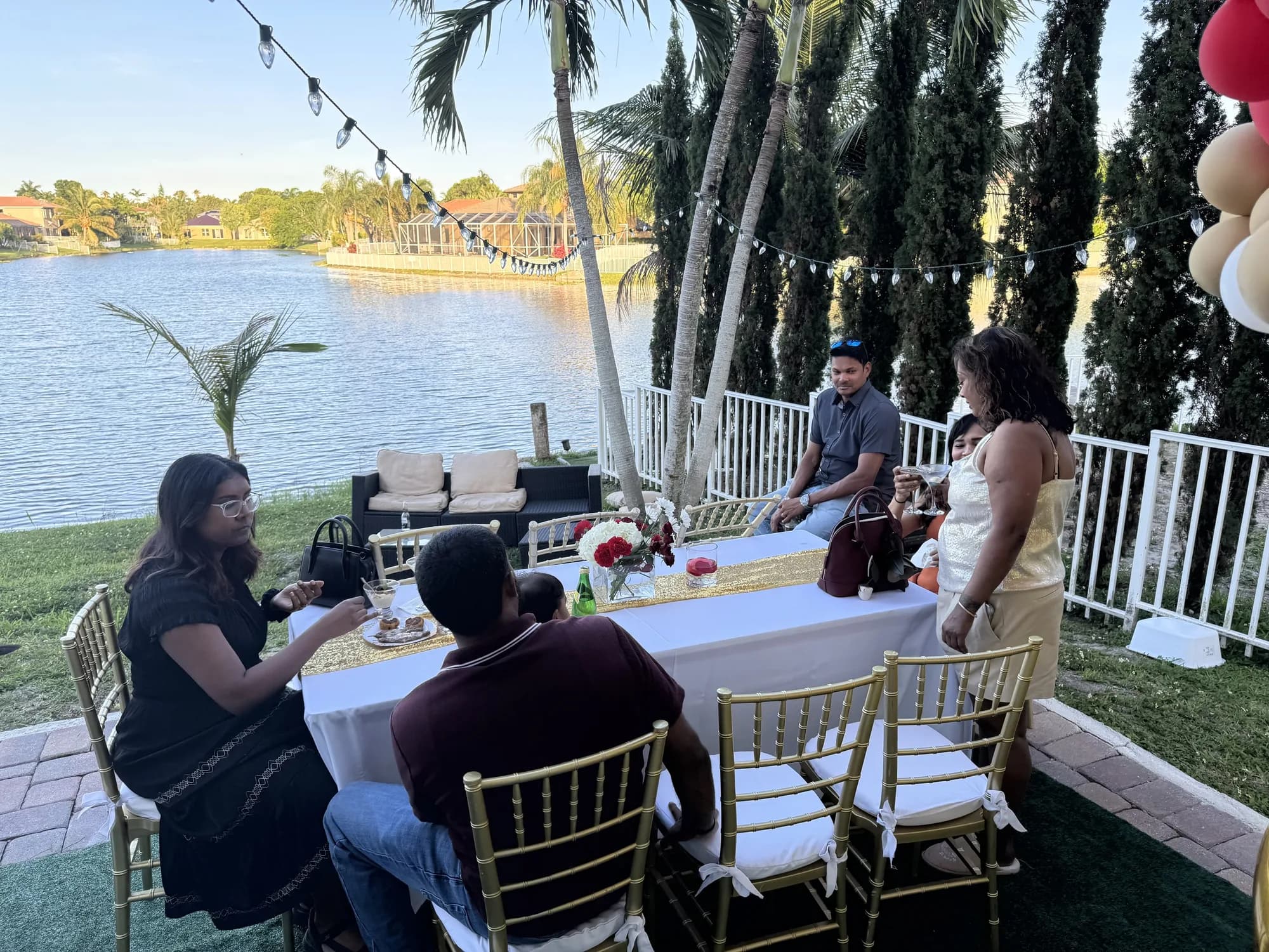 Backyard party with gold chiavari chairs by the lake