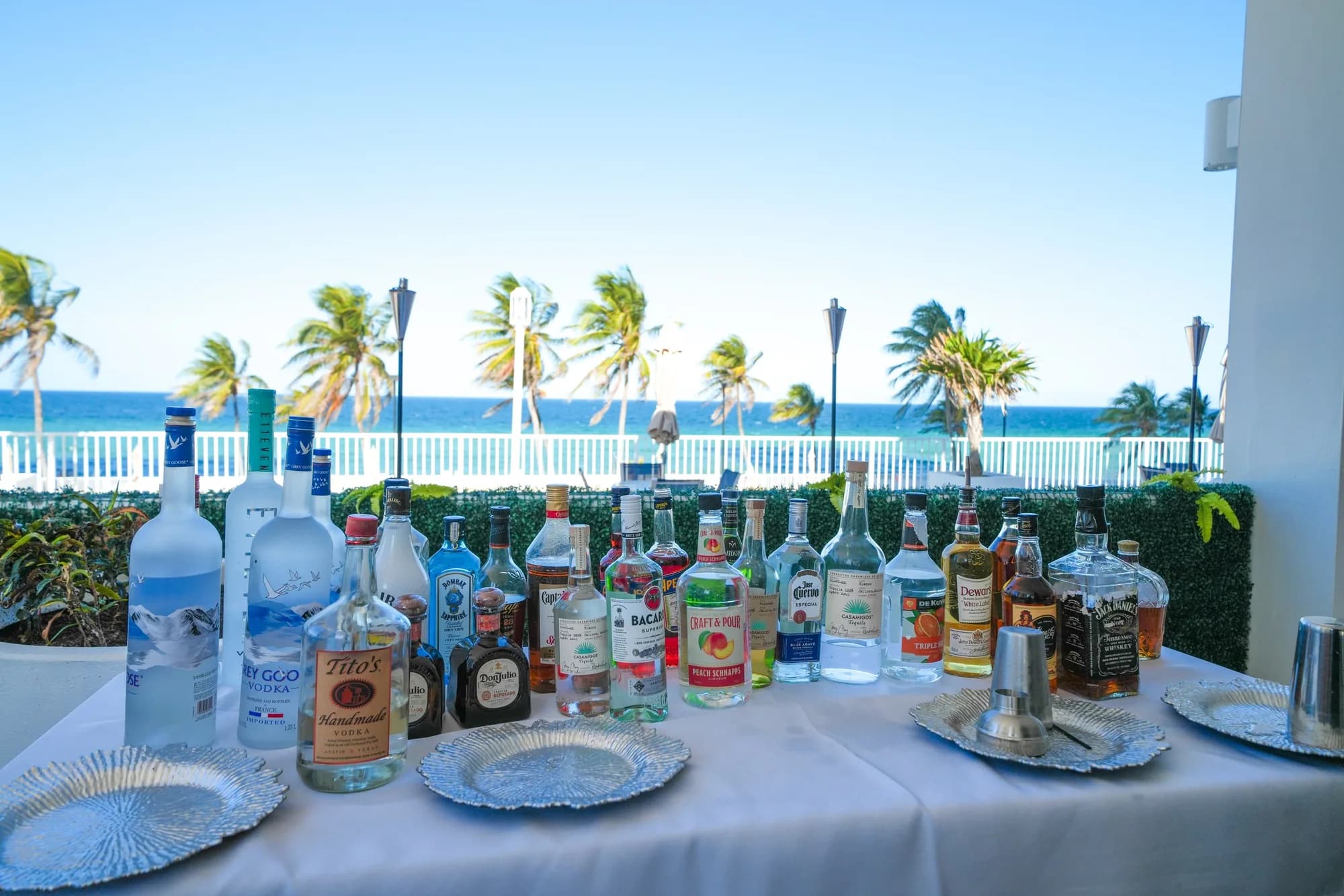 Event bar setup with palm trees and the Atlantic Ocean behind it