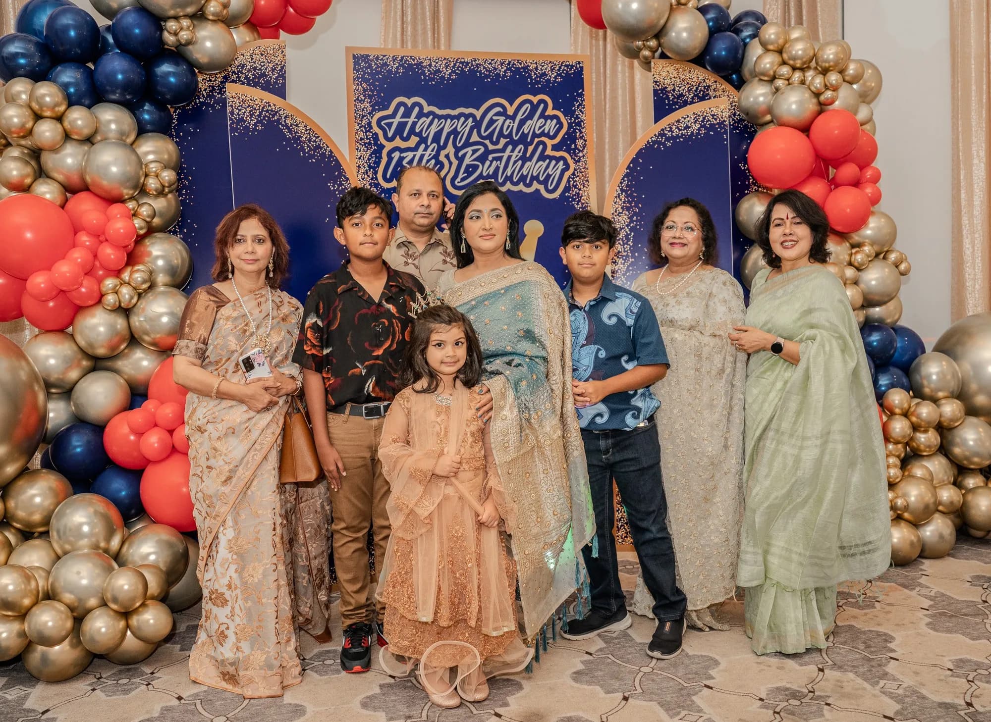 Extended family at a birthday balloon arch