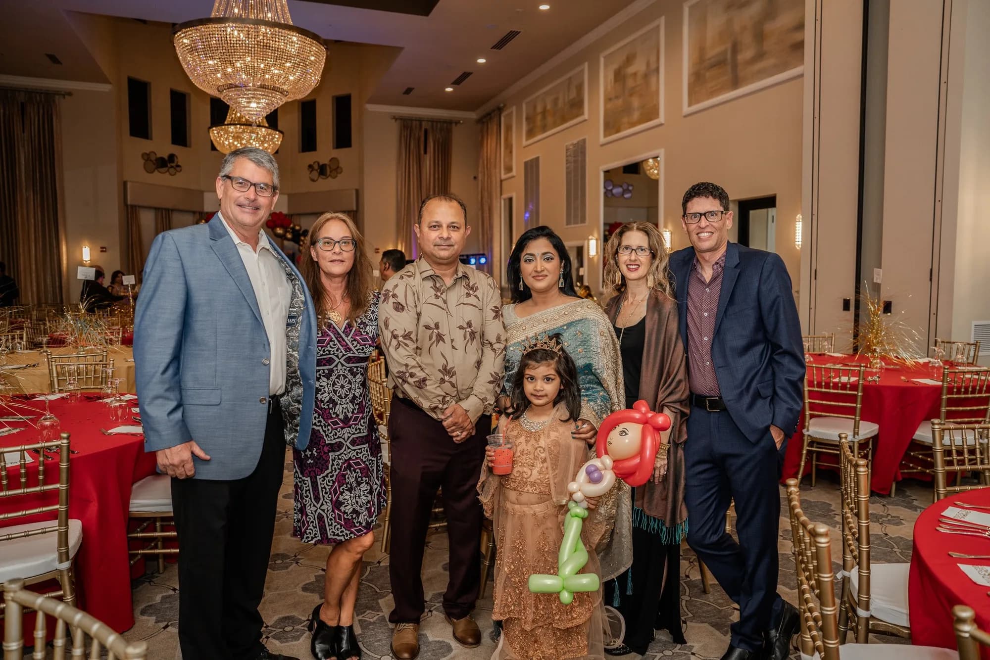 Group photo under a chandelier at a birthday celebration