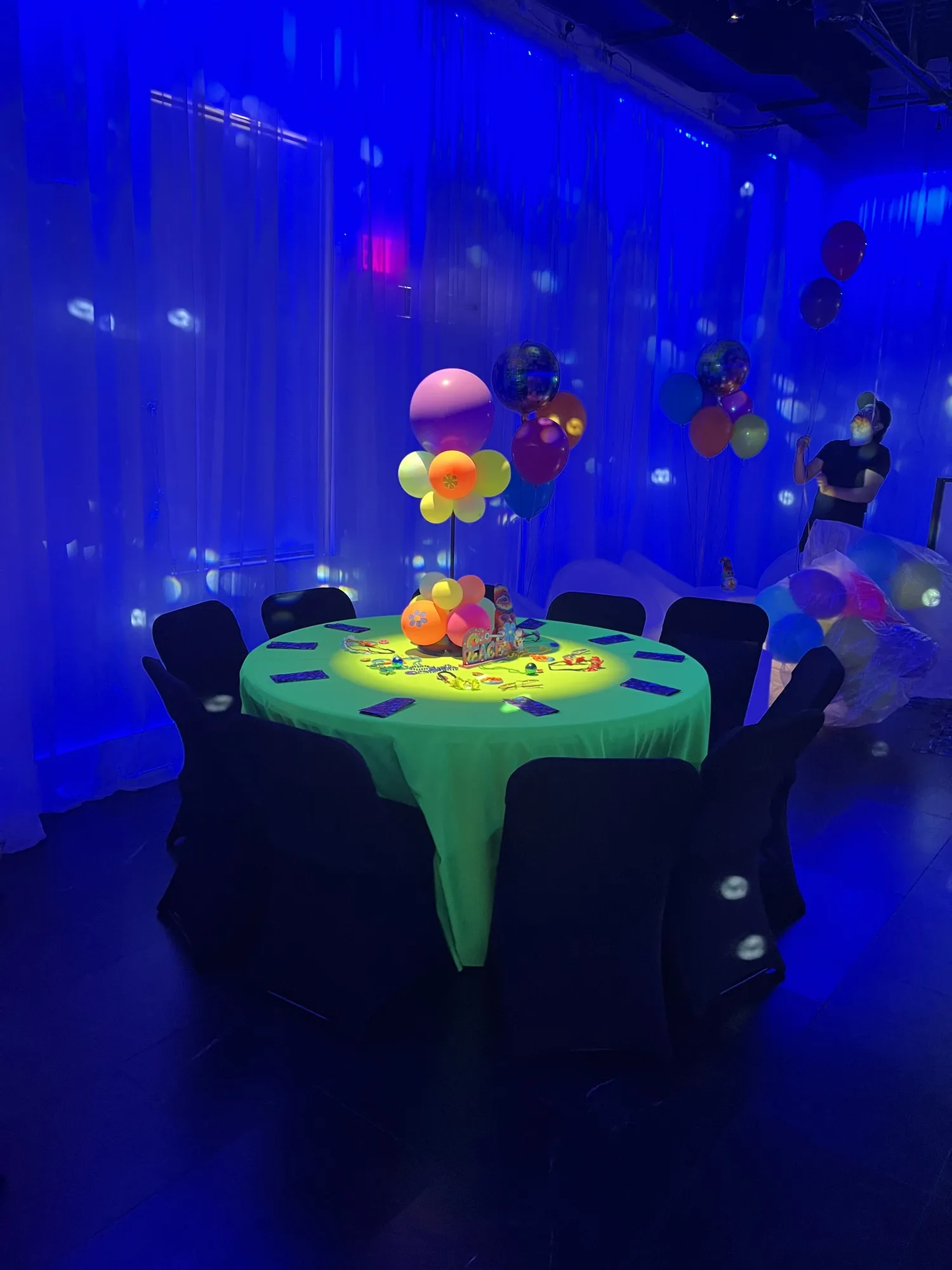 Glow-in-the-dark table under blacklight at a themed party