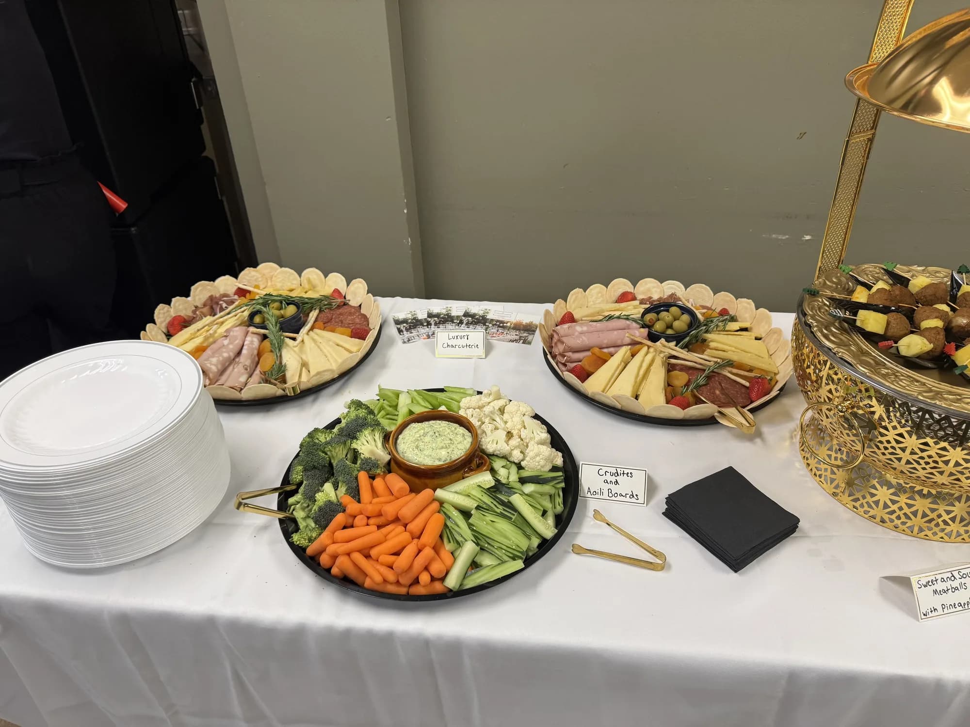 Charcuterie platter with stacked plates at a catered reception