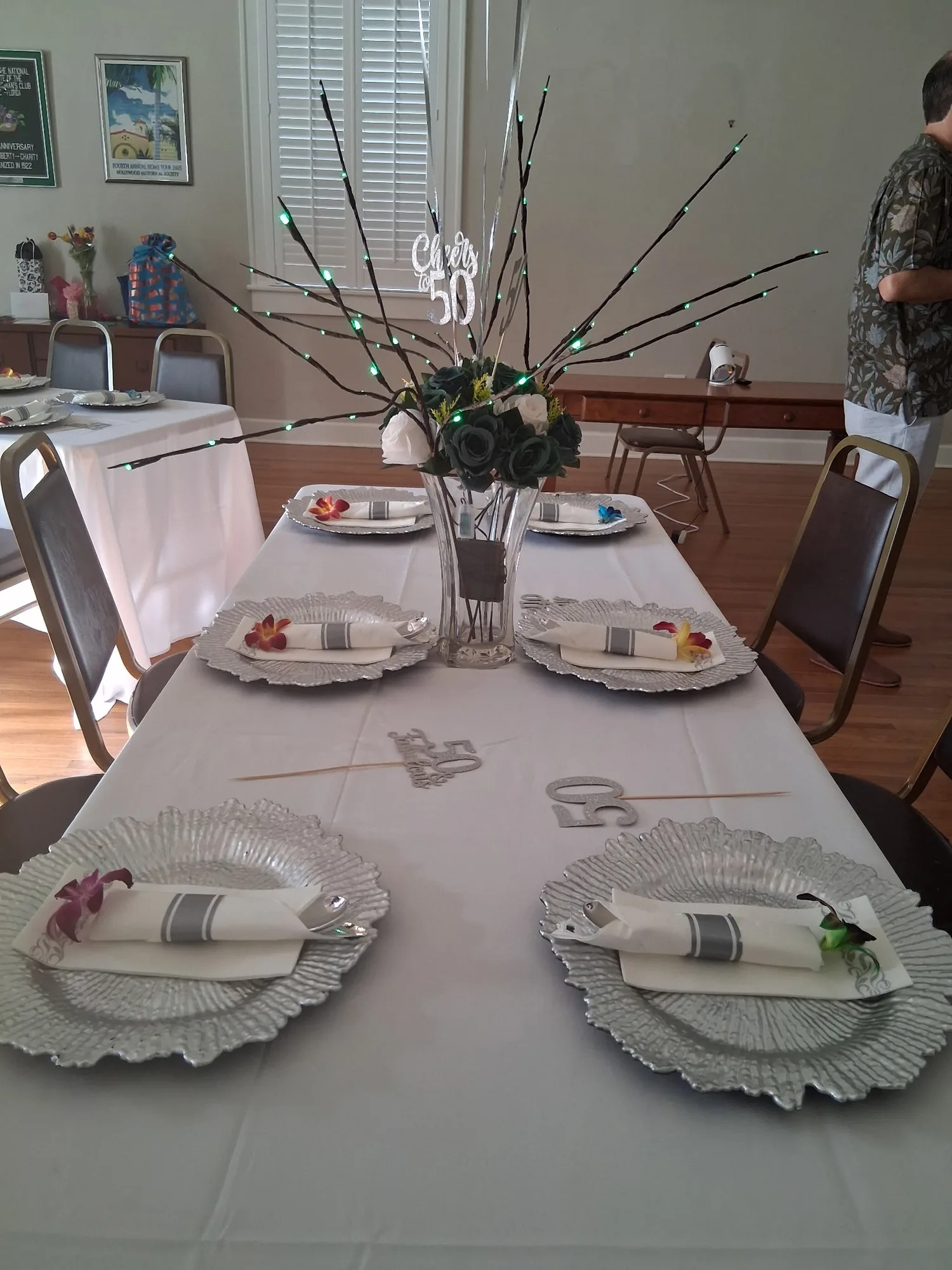 Elegant table setting with silver chargers and floral centerpiece