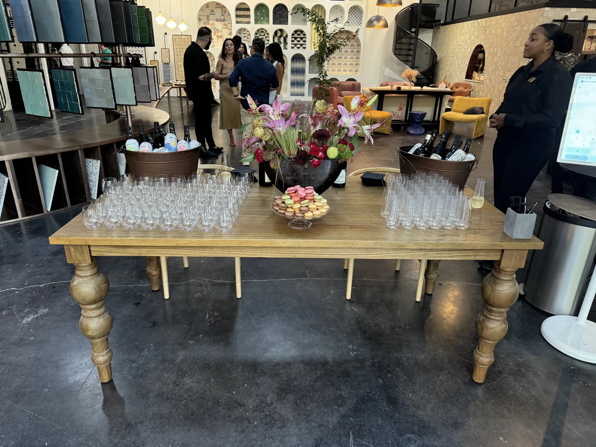 Rented farm table with floral arrangements set up inside an event venue