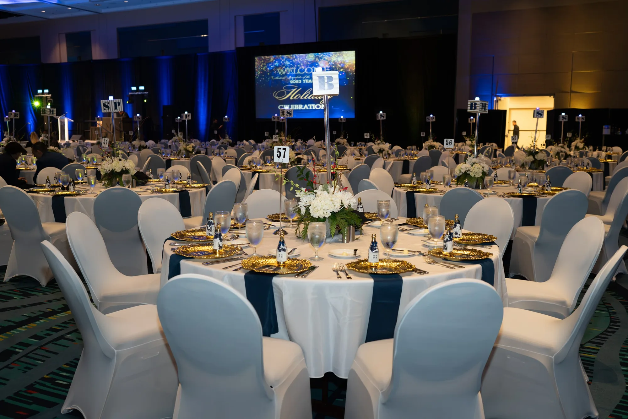 Gala ballroom with round tables and blue uplighting
