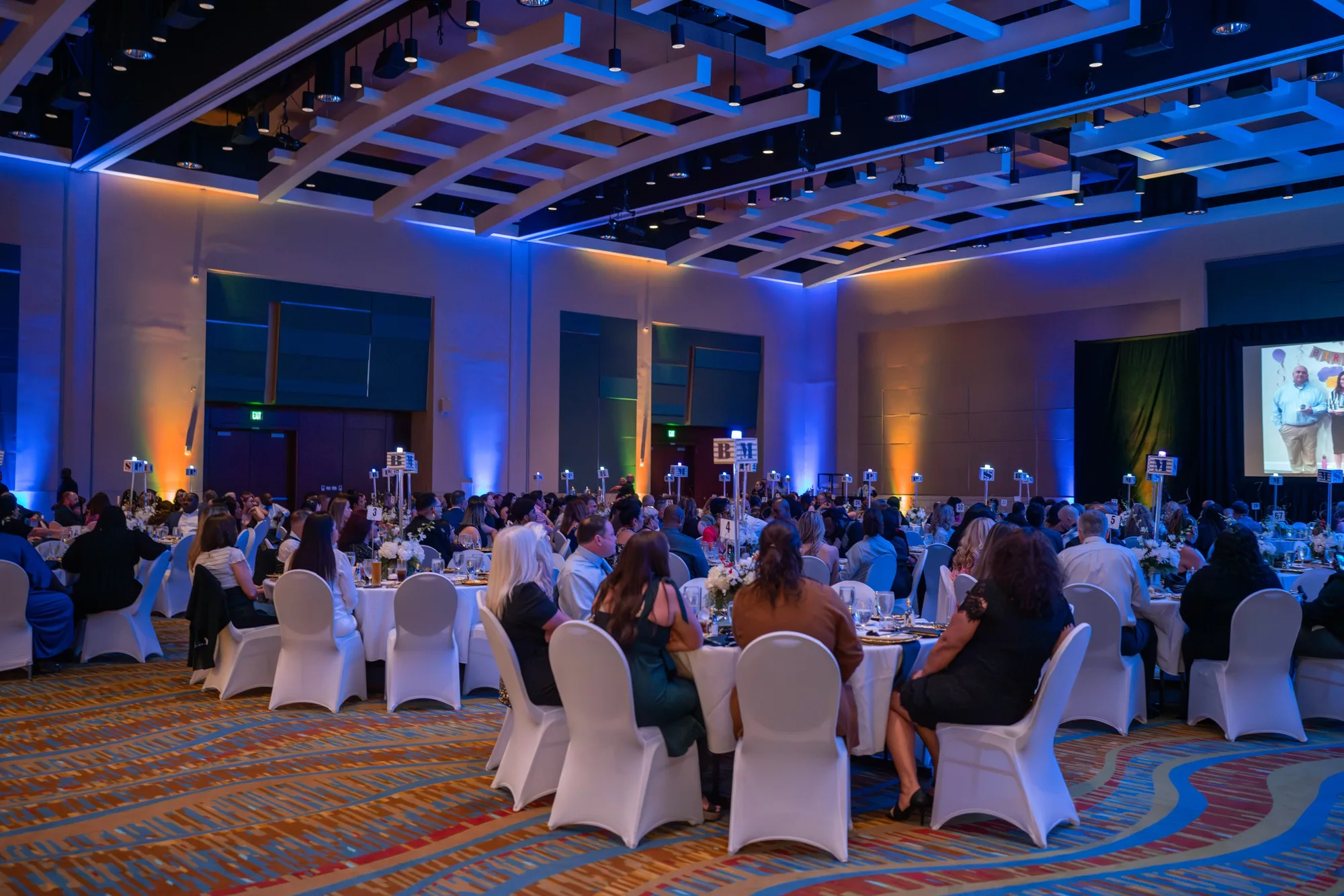 Crowd seated in a ballroom at a gala dinner