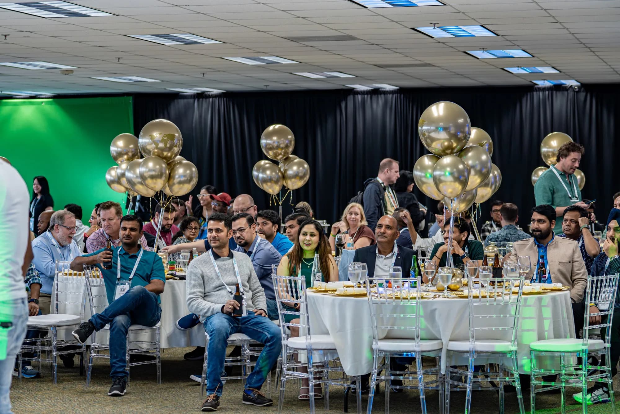 Guests at a gala with gold balloon décor