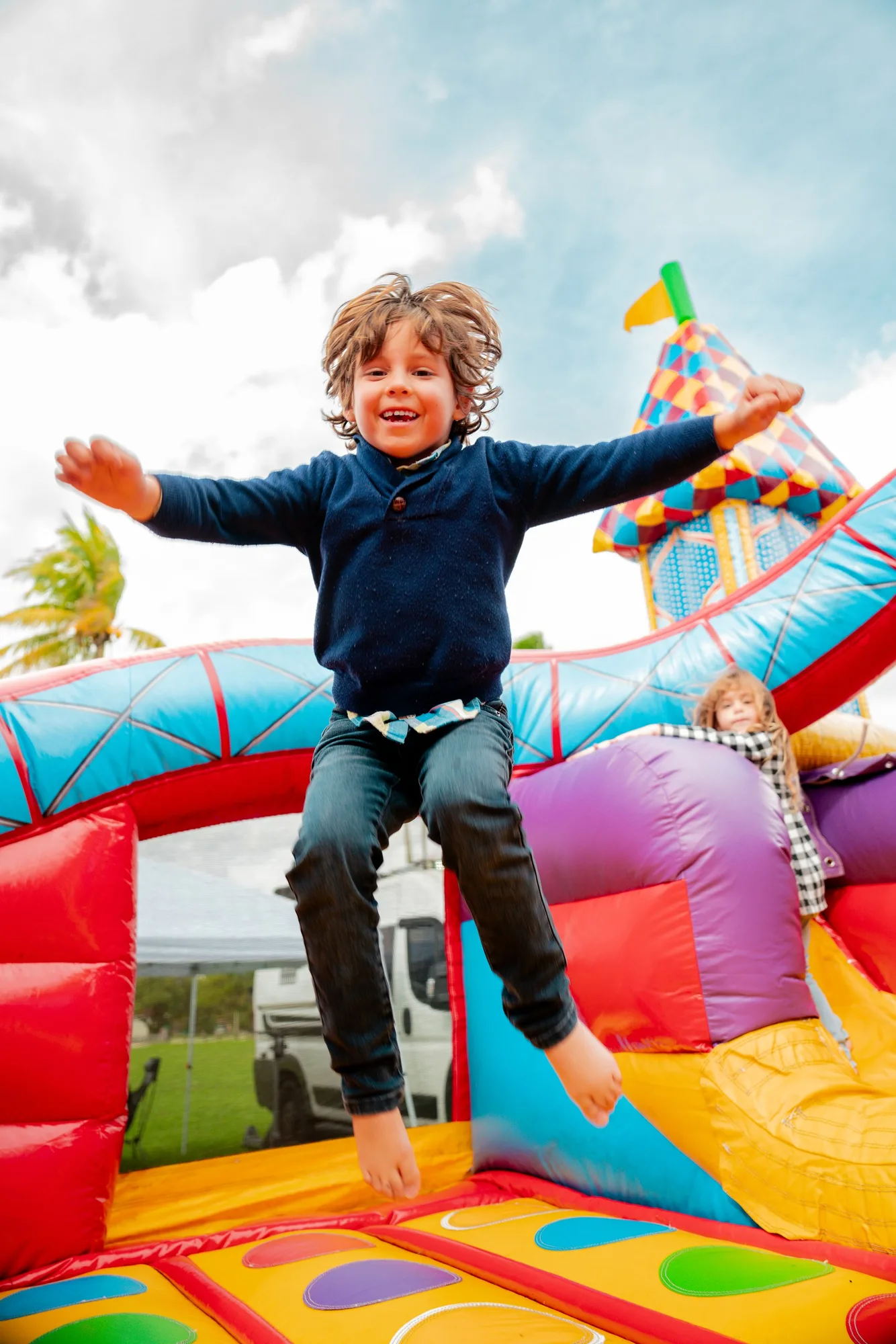 Child jumping on a bounce house at a birthday party