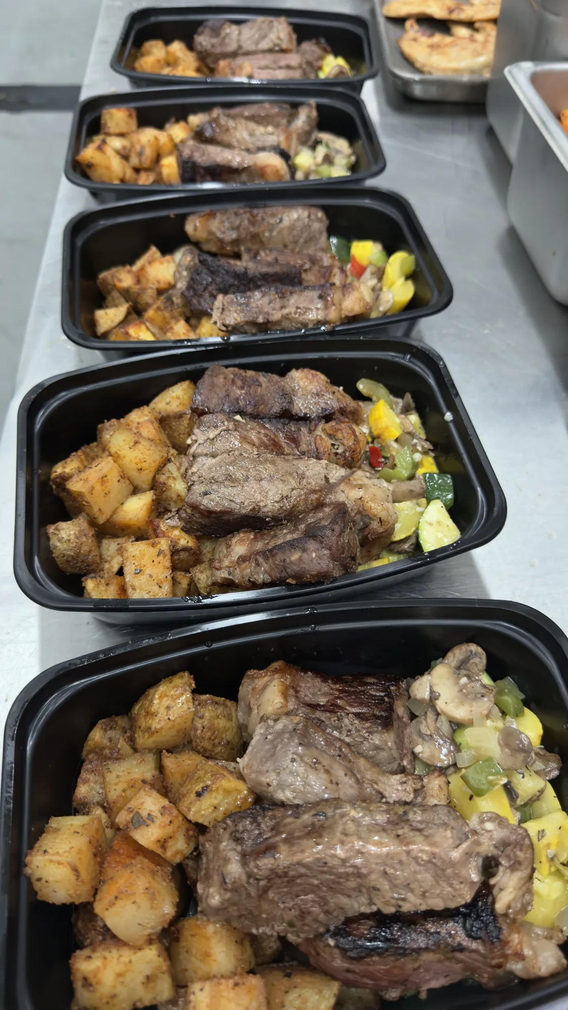 Meal prep containers with steak and roasted potatoes