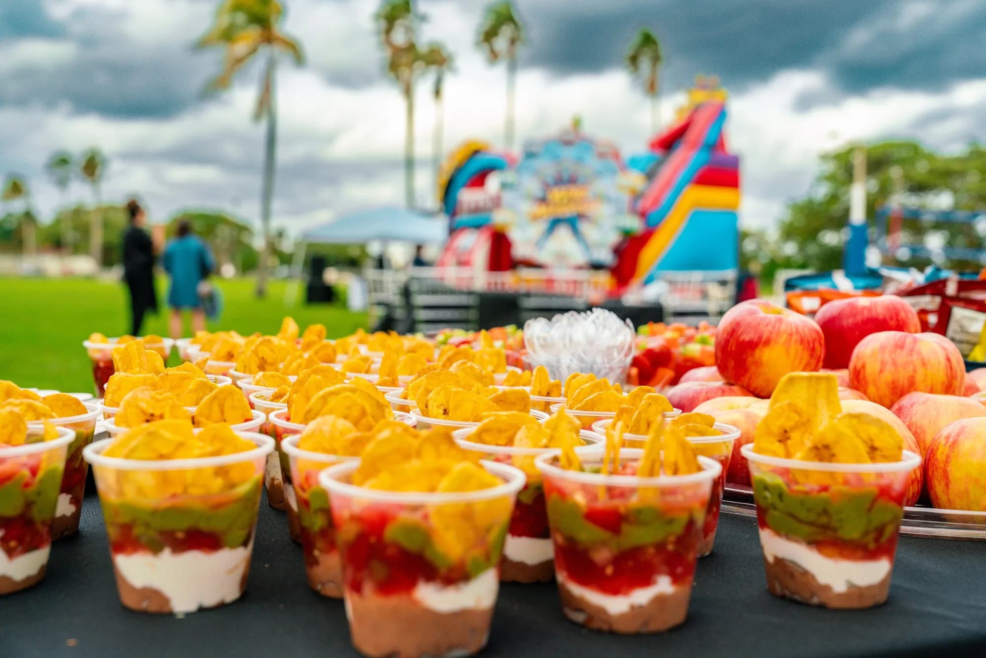 Individual fruit parfait cups and fresh fruit at an outdoor children's party