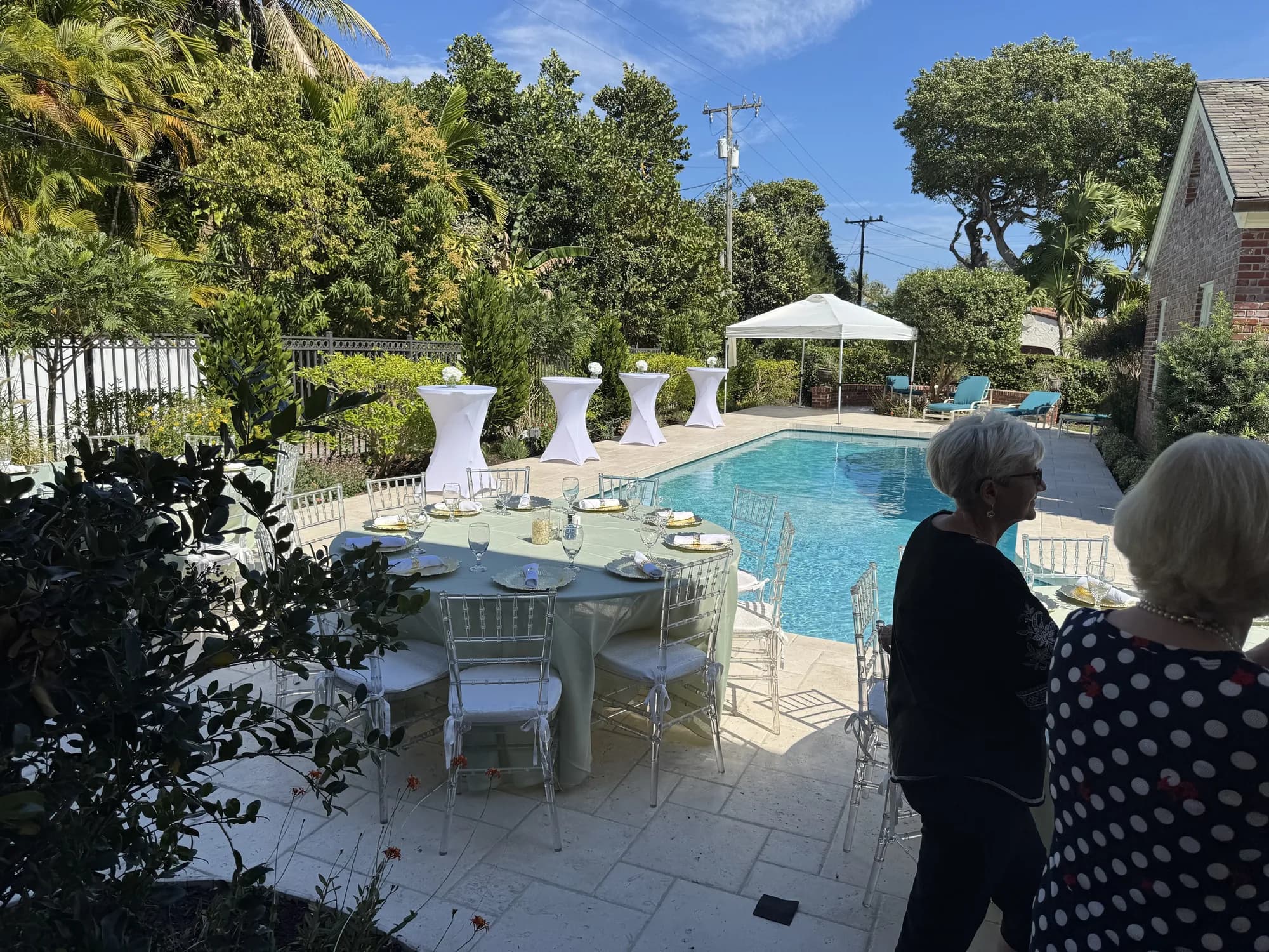 Poolside white tables set for a party
