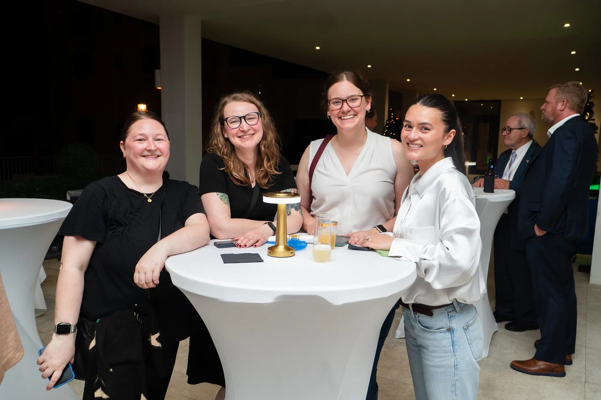 Guests gathered around a cocktail table at a corporate reception